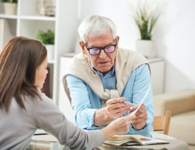 Young social worker or insurance agent asking questions of senior man