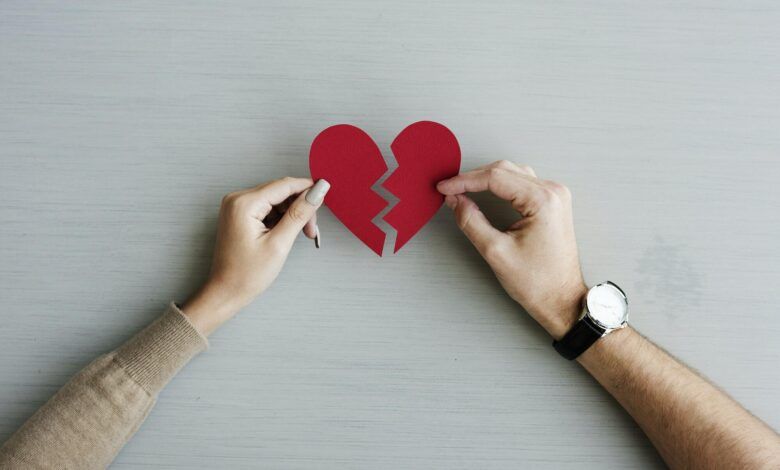 Hands holding a broken paper heart