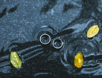 Wedding rings underwater on black background on big yellow leaf
