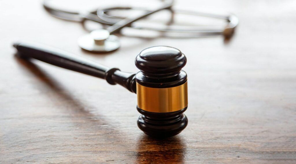 healthcare law medical stethoscope and judge gavel on lawyer office desk