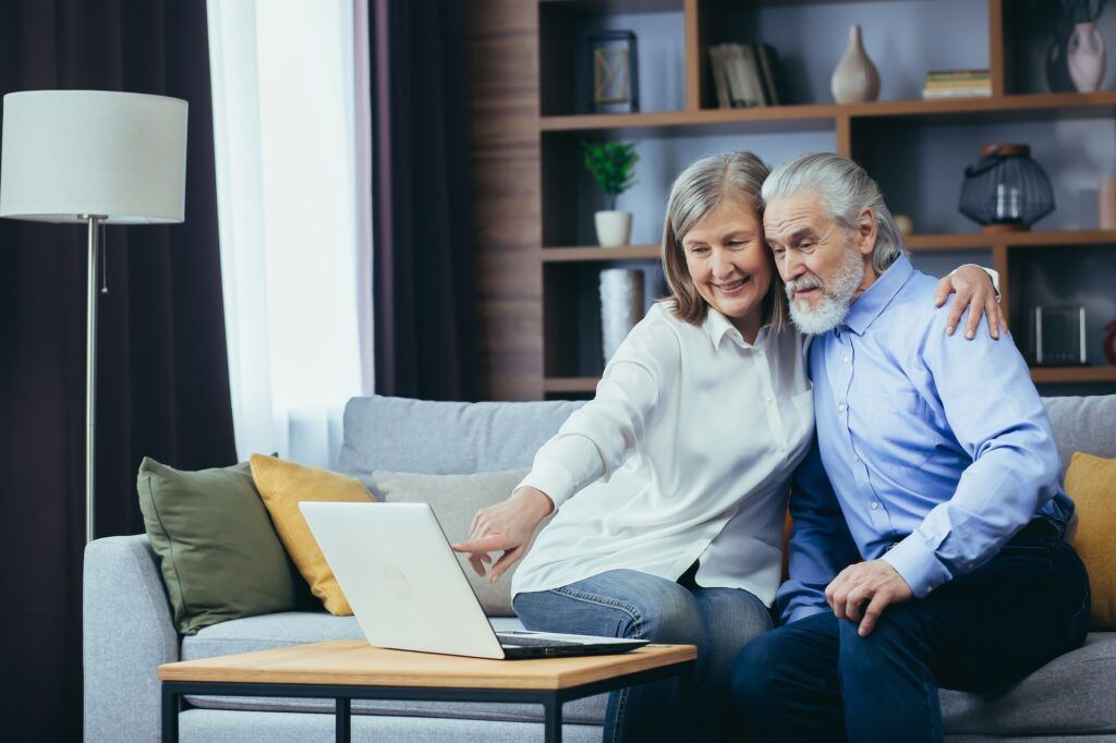 senior couple man and woman shopping online browsing laptop in home elderly family happy retired 1